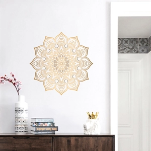 Close-up of golden Mandala wall sticker on a white background with modern home decor items