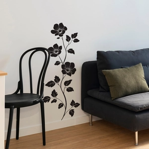 Detail view of black floral vine wall decals with elegant flower silhouettes in a living room