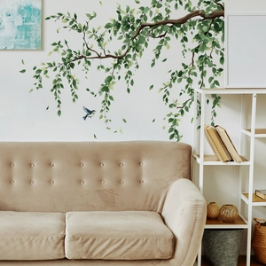 Nature wall sticker featuring a lush tree branch with green leaves and a blue bird on a wall