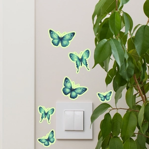 Leuchtende blaue Schmetterling-Wandaufkleber auf weißem Schalter für Wohndeko