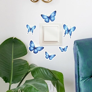 Leuchtende blaue Schmetterling Wandaufkleber am Lichtschalter mit floralem Dekor