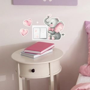 Detailed view of luminous elephant and pink hearts stickers around a white wall switch