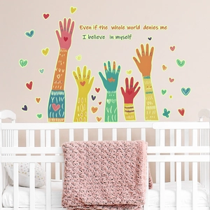 Macro shot of colorful handprint wall stickers with hearts in a cozy nursery room setting