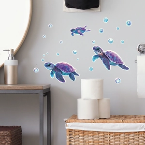 Dettaglio di adesivi murali tartaruga marina luminosa con bolle blu su pareti bagno