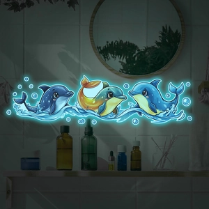 Luminous blue cartoon dolphin wall stickers glowing on bathroom tile wall in dark setting