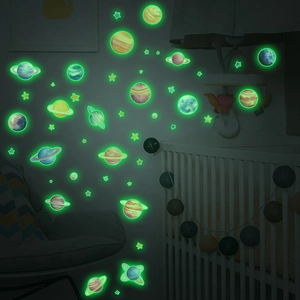 Luminous glow-in-the-dark space planet and star wall stickers in a dark nursery bedroom