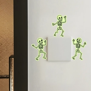 Glow-in-the-dark Halloween skeleton stickers applied around a light switch on a white wall