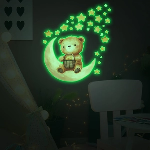 Luminous wall stickers showing a cute brown bear on a glowing moon with stars in the dark