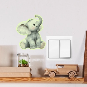Close-up of a cute cartoon elephant wall sticker next to a white light switch in a home setting