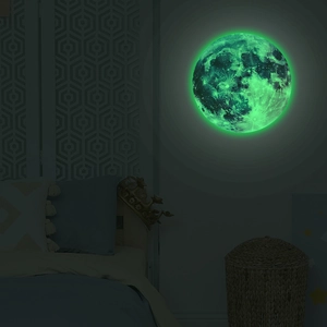 Luminous moon wall sticker showing glowing green texture in dark bedroom scene