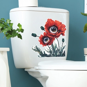 Luminous poppy wall stickers with eye design applied on a white toilet tank