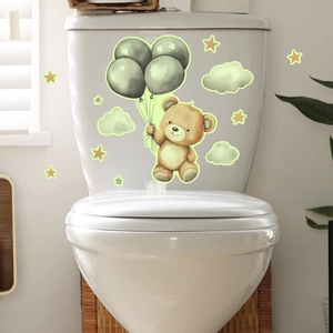 Macro view of glow-in-the-dark toilet stickers featuring a cartoon bear and stars