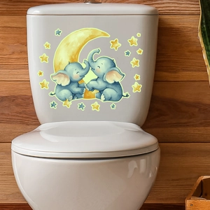 Detail of cartoon elephants and moon glow-in-the-dark stickers applied on a toilet tank
