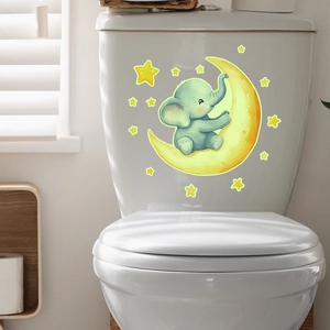 Cute cartoon elephant on yellow moon wall sticker applied on a white ceramic toilet tank