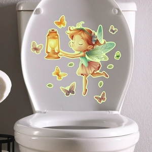 Detailed view of luminous cartoon fairy and butterfly stickers applied on a white toilet lid