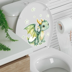 Close-up of a green dragon and stars glowing wall decal on a white toilet lid in a bathroom