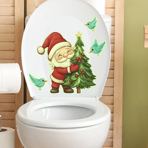 Stickers de Noël lumineux père Noël sur le couvercle blanc d'un abattant WC