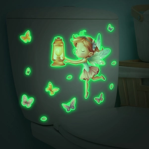 Luminous fairy with lantern and butterflies glowing green on toilet lid in dark