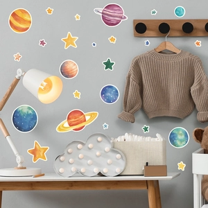 Detail of watercolor space wall stickers with planets and stars in a cozy child's bedroom