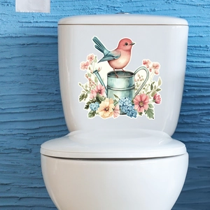 Luminous bird and flower sticker applied on a white ceramic toilet tank surface