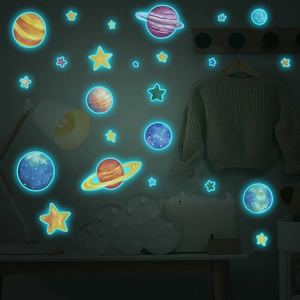 Luminous space wall stickers showing planets and stars glowing blue in dark room