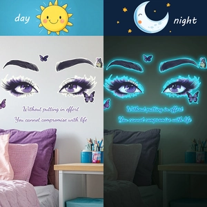 Luminous wall stickers featuring eyes and butterflies glowing cyan in a bedroom setting