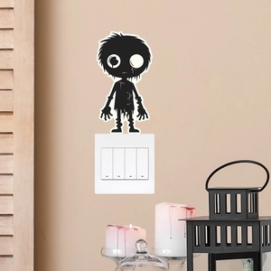 Detail of glow-in-the-dark zombie sticker applied on a white wall light switch