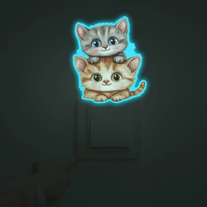 Luminous wall switch sticker showing two cartoon cats glowing blue in dark environment