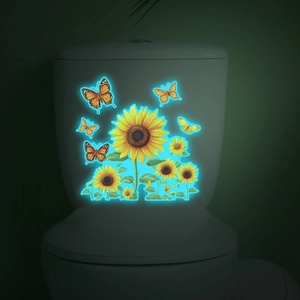 Luminous sunflower and butterfly decals glowing in dark on a white toilet tank