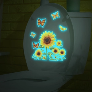 Luminous sunflower and butterfly stickers glowing blue in a dark bathroom environment