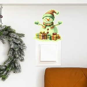 Luminous Christmas snowman sticker glowing on a white light switch with pine decor