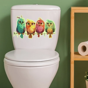 Vue détaillée de quatre autocollants hiboux colorés sur un réservoir de WC blanc