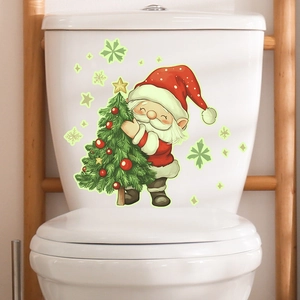 Sticker de toilette lumineux Père Noël et sapin sur un réservoir d'eau blanc