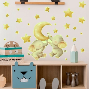 Detailed view of luminous wall stickers featuring cartoon elephants, moon, and stars on a wall