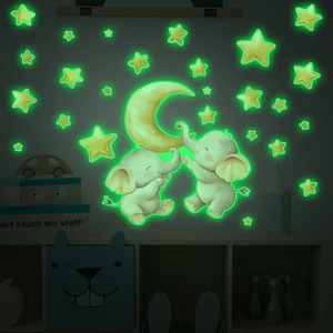 Glow-in-the-dark wall stickers featuring a yellow moon, cartoon elephants, and stars for nursery
