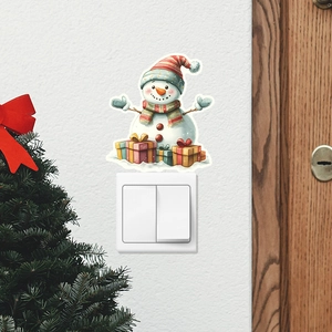 Detailed view of snowman and gift box glowing wall stickers above a light switch