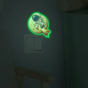 Luminous astronaut and moon wall stickers glowing in green for light switch decor