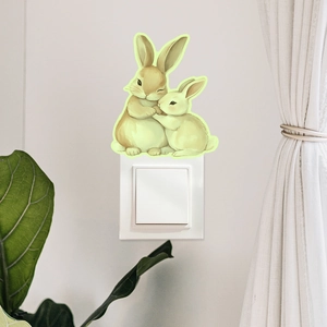 Glow-in-the-dark wall sticker featuring hugging rabbits placed above a white light switch