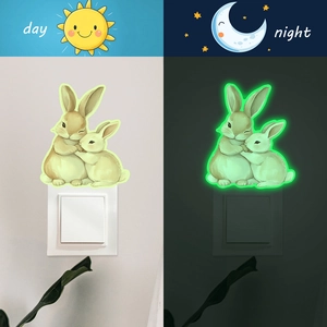 Luminous wall sticker with two hugging rabbits showing day and night glowing effects
