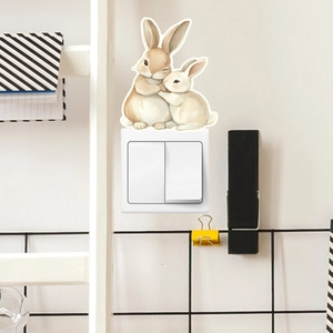 Detailed view of luminous cartoon bunny stickers applied on a white light switch plate