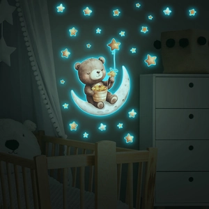 Luminous wall sticker showing a bear on a moon with glowing stars in a cozy nursery room