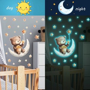 Glow in the dark wall stickers featuring bear on moon and stars in day and night views
