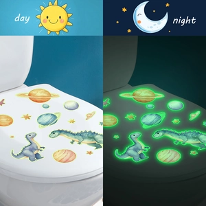 Glow-in-the-dark dinosaur and planet toilet lid stickers shown in day and night views