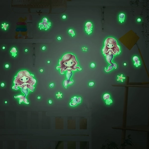 Glow-in-the-dark mermaid and jellyfish wall stickers illuminating a dark bedroom