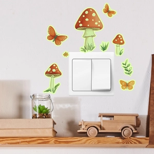 Stickers muraux lumineux avec champignons rouges et papillons autour d'un interrupteur