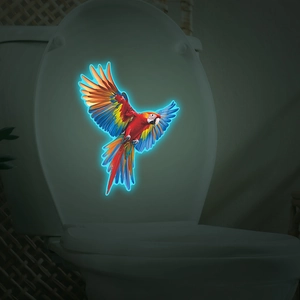 Luminous colorful flying macaw parrot decal glowing on white toilet lid in the dark