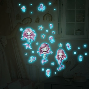 Luminous cartoon mermaid and jellyfish wall decals glowing bright blue in the dark room
