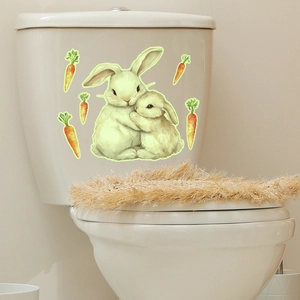 Stickers lumineux de lapins et carottes appliqués sur un réservoir de toilettes blanches
