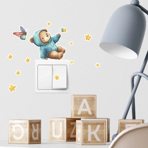 Detailed view of cartoon bear, butterfly and stars glow stickers around wall switch
