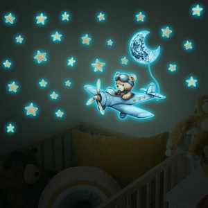 Luminous wall stickers showing a blue glowing bear flying a plane with moon and stars